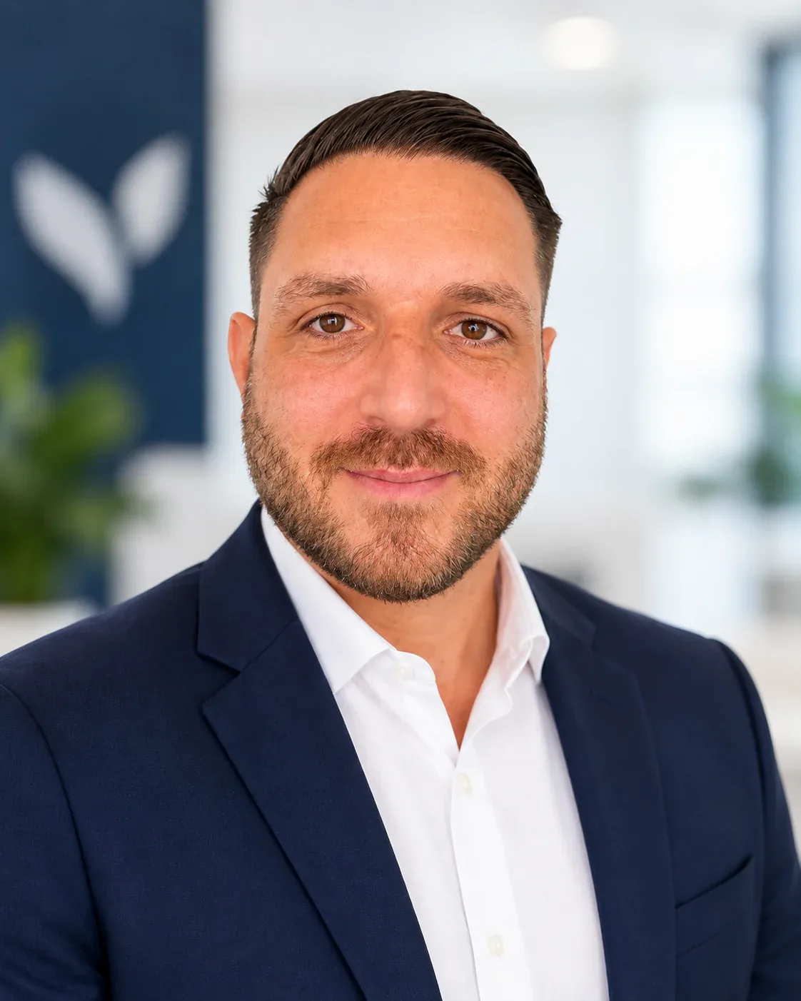 Marcel Scherres, Head of Sales bei NeoVital, im dunkelblauen Sakko vor einem Büro